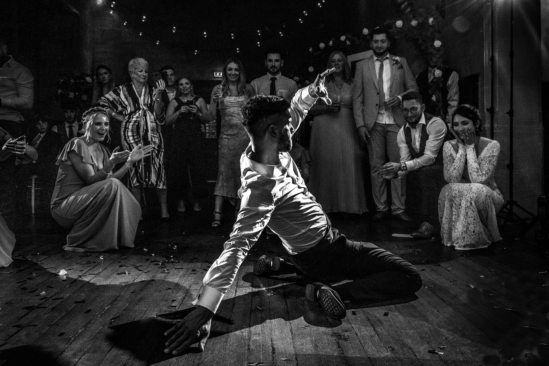 Groom dancing on the dance floor while bride and guests watch